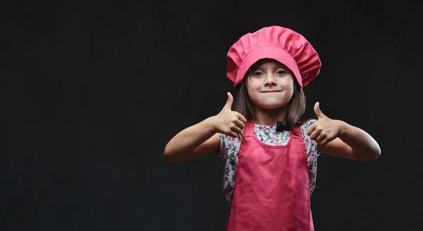 Menina Bonito Vestido Rosa Cozinhar Posando Com Polegares Para Cima — Fotografia de Stock