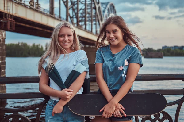 Δύο Χαρούμενος Νεαρός Hipster Κορίτσια Κατέχει Ένα Skateboard Και Ακουμπά — Φωτογραφία Αρχείου