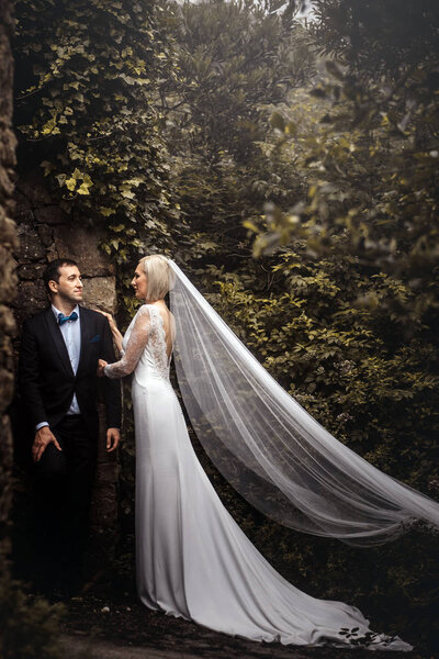 Lovely couple of newlyweds - bride and groom hugging in a beautiful mystery forest.