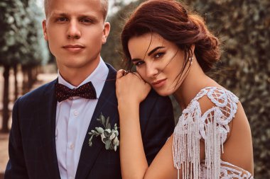 Yeni evliler - yakın çekim portre sevimli gelin başını parkta onun yakışıklı damat üzerinde koydu.