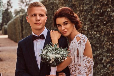 Yeni evliler - yakın çekim portre sevimli gelin başını parkta onun yakışıklı damat üzerinde koydu.