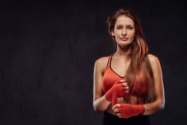 Spor sutyeni güzel bir esmer kadın boksör portresi elleri sargı bezi. Karanlık dokulu arka plan üzerinde izole.