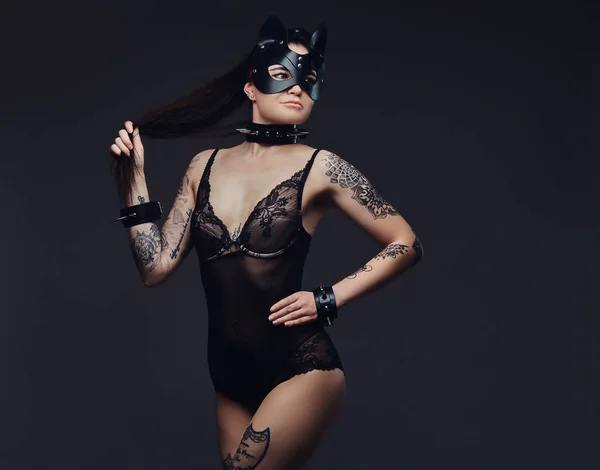 魅惑的な官能的な愛人女の子 Bdsm アクセサリーと暗い背景にポーズ猫革マスクの黒のランジェリーを身に着けています 暗い背景に分離 — ストック写真