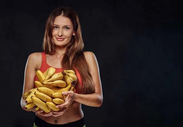 Mulher Morena Sorridente Vestida Com Sutiã Esportivo Segura Bananas Oncept — Fotografia de Stock