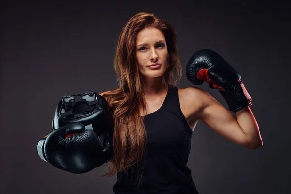 スポーツウェア着てボクシング グローブに身を包んだ陽気な女性は 保護用のヘルメットを保持します 暗い背景に分離 — ストック写真