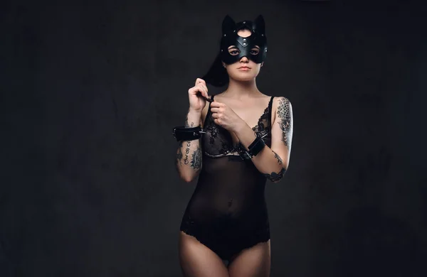Seksowny kobieta nosi czarny Bielizna Bdsm kot skórzane maski i akcesoria pozowanie na ciemnym tle. — Zdjęcie stockowe
