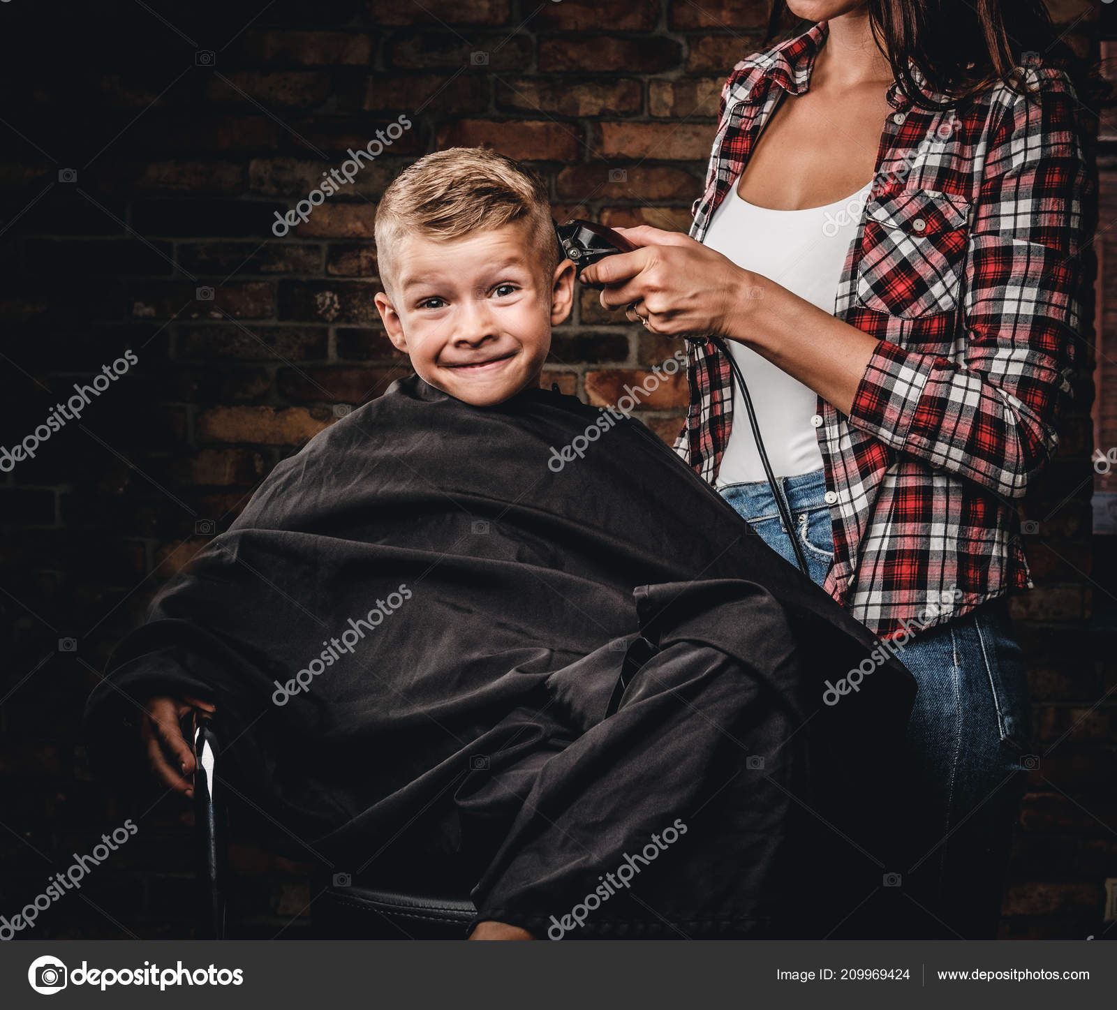 Funny preschooler boy getting haircut. Children hairdresser with the trimmer  is cutting little boy in the room with loft interior. Stock Photo by  ©fxquadro 209969424