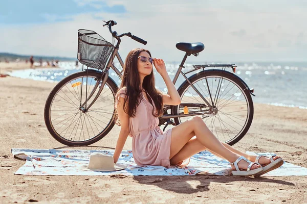 Charmante jeune femme en lunettes de soleil et robe profiter des vacances sur la plage . — Photo