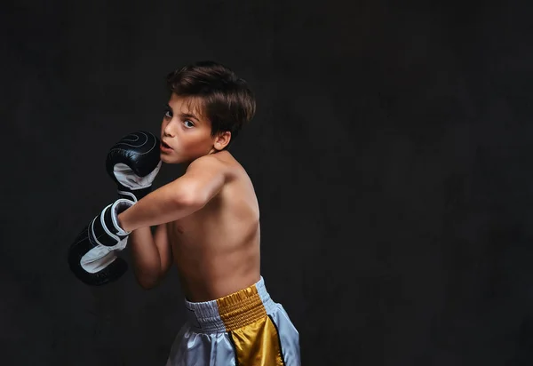 Przystojny shirtless młody bokser podczas ćwiczeń bokserskich, koncentruje się na proces z poważnych skoncentrowany na twarz. Na białym tle na ciemnym tle. — Zdjęcie stockowe