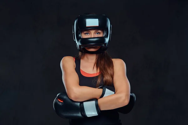 Retrato de cerca de una boxeadora con guantes y casco protector posando en un estudio. Aislado sobre fondo de textura oscura . —  Fotos de Stock