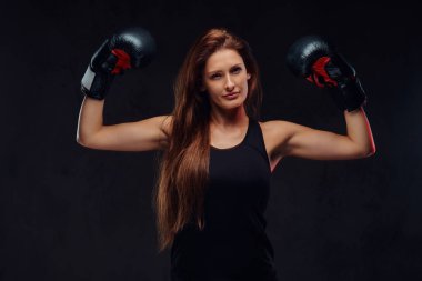 Spor giyim giyen boks eldivenleri, güzel sportif kadın boksör kasları gösterir. Karanlık dokulu bir arka plan üzerinde izole.