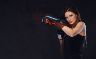 Güzel esmer kadın boksör boks egzersizleri sırasında ciddi konsantre yüz ile bir süreç odaklı.