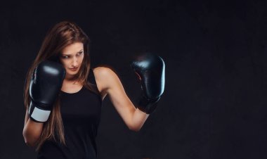 Güzel esmer kadın boksör boks egzersizleri sırasında ciddi konsantre yüz ile süreci odaklı.