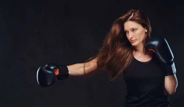 Belle boxeuse brune pendant les exercices de boxe, axée sur un processus avec un visage concentré sérieux . — Photo