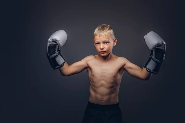 Jovem pugilista sem camisa com luvas de boxe posando em um estúdio . — Fotografia de Stock