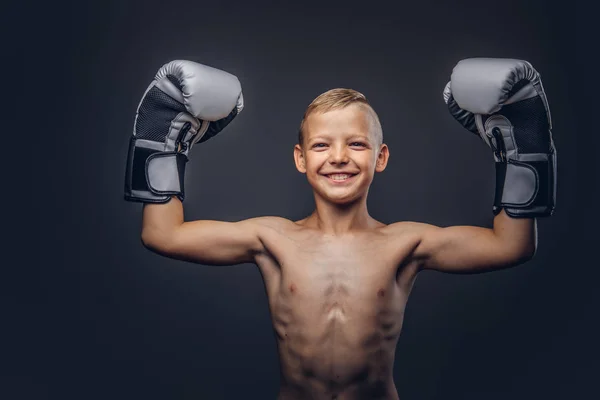 Vrolijke shirtless kleine jongen boxer met blonde haren dragen van bokshandschoenen verheugt zich in een overwinning. — Stockfoto