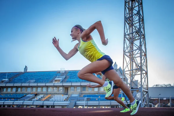 Dos atletas de velocista corriendo en la carrera de la cinta de correr durante el entrenamiento en el estadio de atletismo . — Foto de Stock