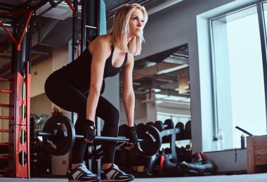 Spor giyim deadlift ile halter fitness club veya spor salonu yapıyor sarışın sportif kadın.