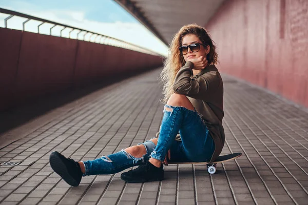 Portrait Pensive Girl Sunglasses Dressed Hoodie Ripped Jeans Sitting Skateboard — Stock Photo, Image