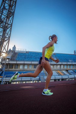 Genç kadın sprinter atlet atletizm Stadyumu eğitim sırasında koşu yarışı üzerinde çalışan.