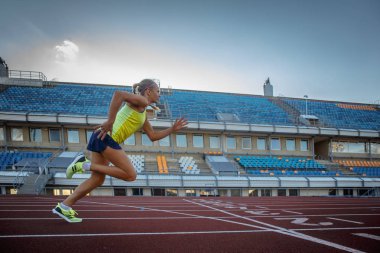 Genç kadın sprinter atlet atletizm Stadyumu eğitim sırasında koşu yarışı üzerinde çalışan.