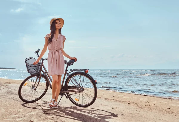 幸せな魅力的な女の子を着たドレスと帽子の晴れた日に自転車でポーズ — ストック写真
