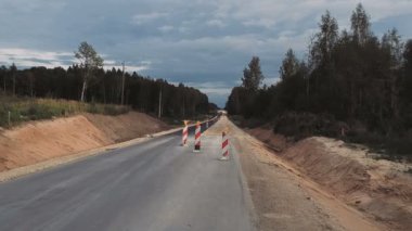 Ormanın ortasında bir asfalt yol inşaatı.