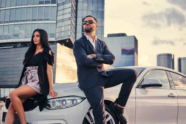 Well Dressed Attractive Couple Leaning Luxury Car Outdoors Skyscraper — Stock Photo, Image