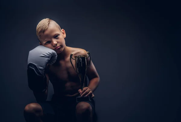 Mladí Košili Boy Drží Pohár Vítězů Při Sezení Židli Tmavém — Stock fotografie