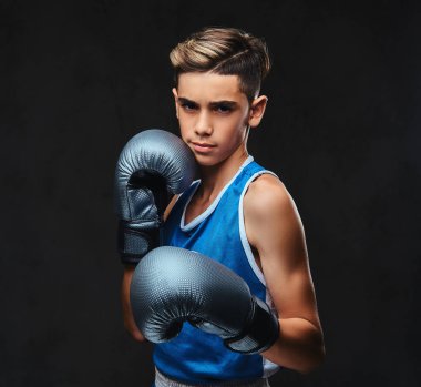 Spor giyim eldiven giymiş yakışıklı bir genç boksör portresi. Karanlık bir arka plan üzerinde izole.