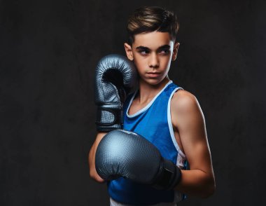 Spor giyim eldiven giymiş yakışıklı bir genç boksör portresi. Karanlık bir arka plan üzerinde izole.