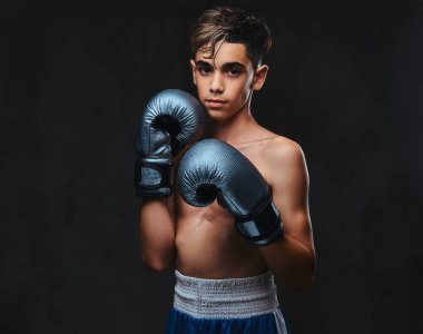 Eldiven giymiş yakışıklı gömleksiz genç boksör portresi. Koyu arka plan üzerinde izole.