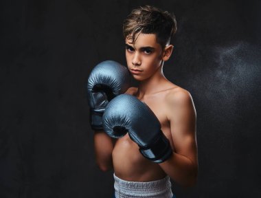 Eldiven giymiş yakışıklı gömleksiz genç boksör portresi. Koyu arka plan üzerinde izole.