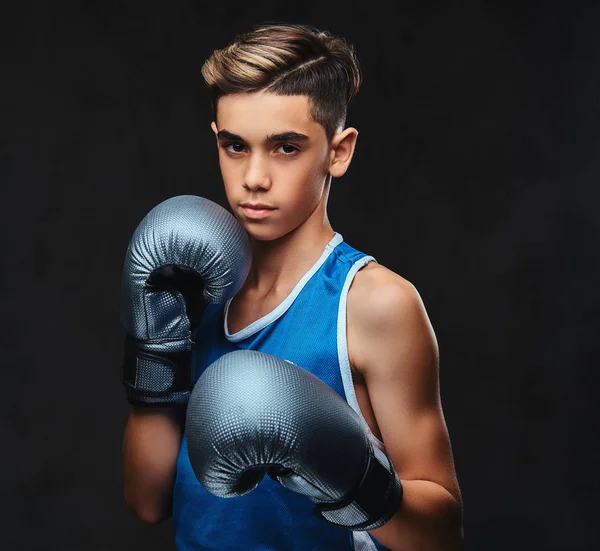 Spor giyim eldiven giymiş yakışıklı bir genç boksör portresi. Karanlık bir arka plan üzerinde izole.