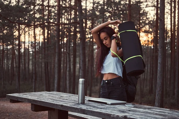 Chica turística va a ir más lejos después de un descanso en el hermoso bosque de otoño durante el atardecer . — Foto de Stock