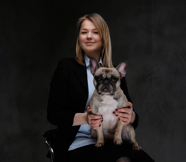 Happy blonde woman breeder sitting on a chair and holds her cute pug. — Stock Photo, Image