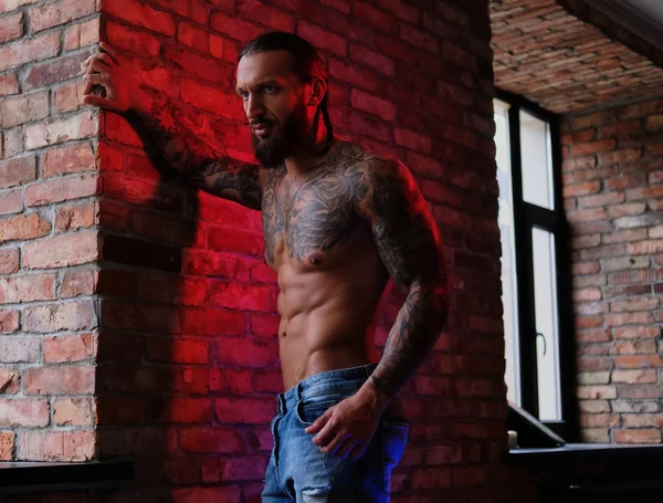 Brutal barbudo tatuado macho posando contra la pared de ladrillo . — Foto de Stock