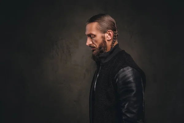 Perfil de um homem barbudo na moda em uma jaqueta preta. Isolado em fundo escuro texturizado . — Fotografia de Stock
