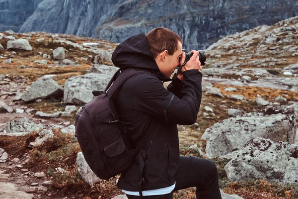 Turista fotógrafo de naturaleza con fotos de cámara mientras está de pie en la montaña . — Foto de Stock