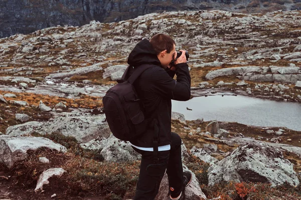 Fotógrafo de natureza turista com tiros de câmera enquanto está em pé na montanha . — Fotografia de Stock