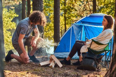 Genç uzun yürüyüşe çıkan kimse iki orman kampında. Genç adam bir ateş yakıp dener. 