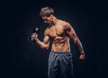 Yakışıklı gömleksiz adam şık saç ve kas ectomorph vücut egzersizleri dumbbells ile yapıyor.
