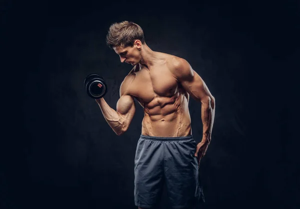 Hombre guapo sin camisa con el pelo elegante y el cuerpo ectomorph muscular haciendo los ejercicios con pesas . — Foto de Stock