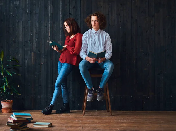 Couple de jeunes étudiants avec des livres dans une chambre à l'intérieur minimaliste . — Photo