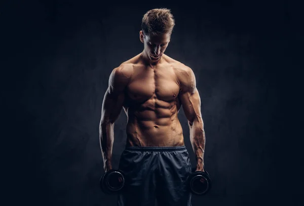 Bonito homem sem camisa com cabelo elegante e corpo ectomorfo muscular fazendo os exercícios com halteres . — Fotografia de Stock