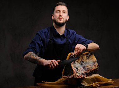 Şef yemek bir tabloda koyu arka plan üzerinde bir av evde özel kurutulmuş et kesme.