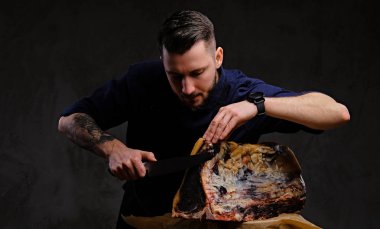 Odaklı şef yemek bir tabloda koyu arka plan üzerinde bir av evde özel kurutulmuş et kesme.