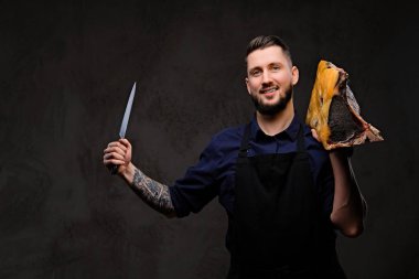 Smirking Şef aşçı tutan bıçak ve büyük özel tedavi et parçası üzerinde koyu arka plan.