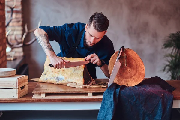 Chef cook cutting exclusive jerky meat on table in a kitchen with loft interior. — Stock Photo, Image