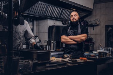 İki acımasız aşçılar bir mutfak suşi hazırlama üniforma giymiş.